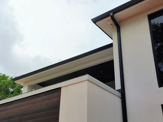 Black seamless gutters installed to complement a modern home exterior.