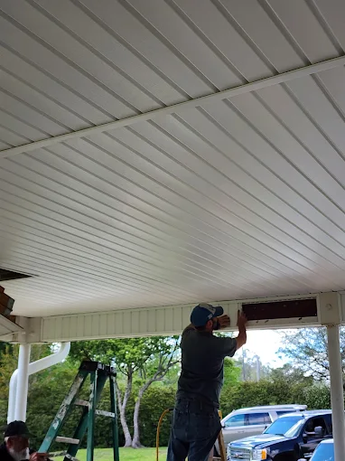 Soffit installation in progress beneath a large covered residential patio.