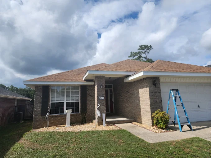 New seamless gutters installed along the roofline of a one-story brick home.