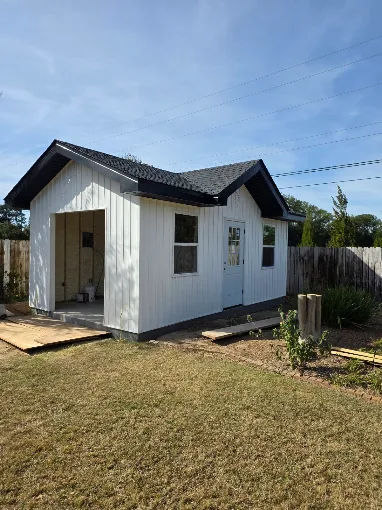 New gutters installed on a compact home with a dark roof and light exterior.