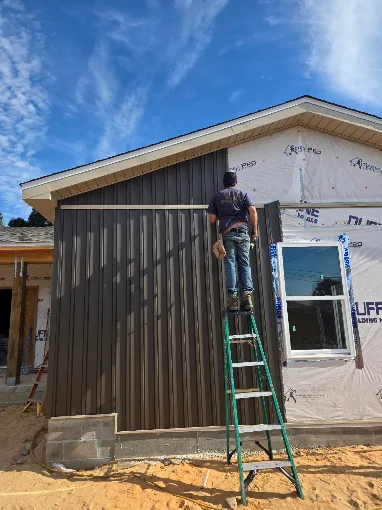 Exterior contractor installing soffit and fascia materials on a home addition.